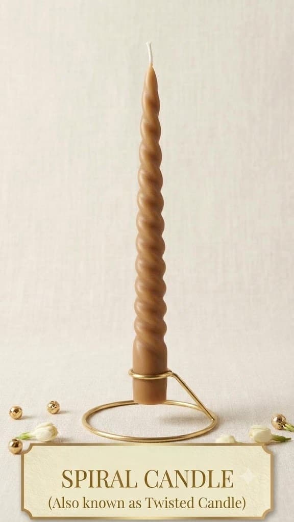 A tall caramel-coloured twisted taper candle standing in a round brass holder on cream linen with jasmine buds and gold beads, captioned Spiral Candle, also known as Twisted Candle.